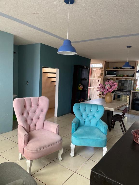 a living room with two chairs and a table at Hermosa casa con dos habitaciones y dos baños in Cerro Gordo