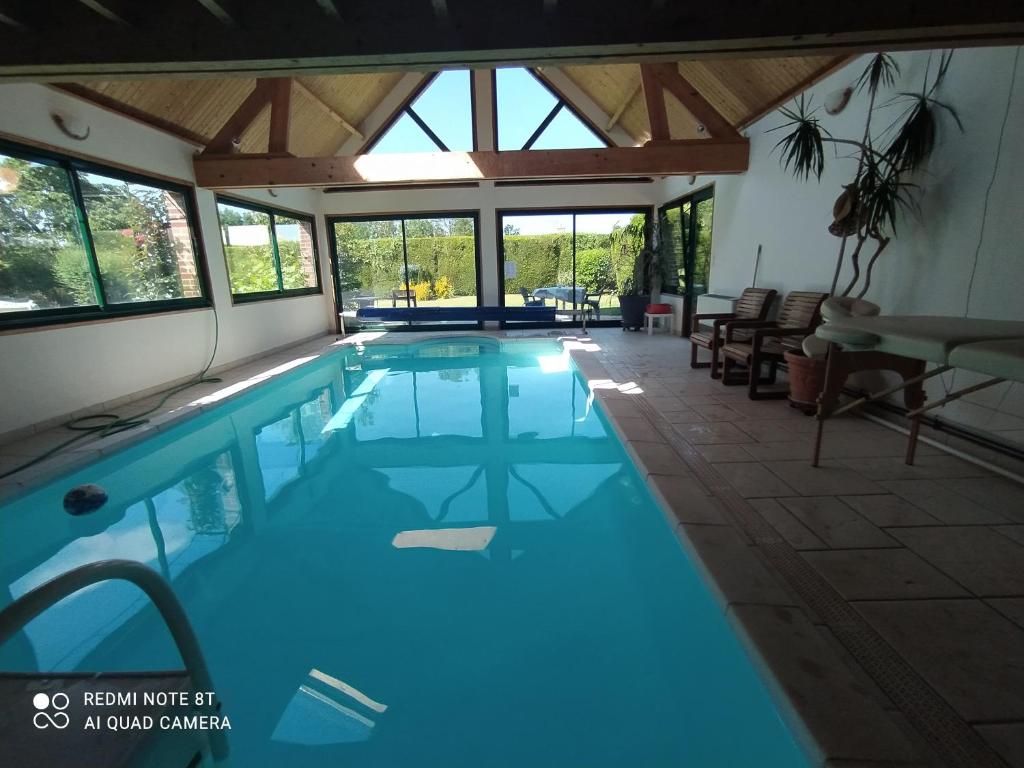a swimming pool with blue water in a house at Au Nid d'Amour in Clarques