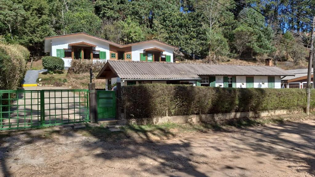 een huis met een hek ervoor bij Pousada Florada na Serra - Apto 5 in Campos do Jordão