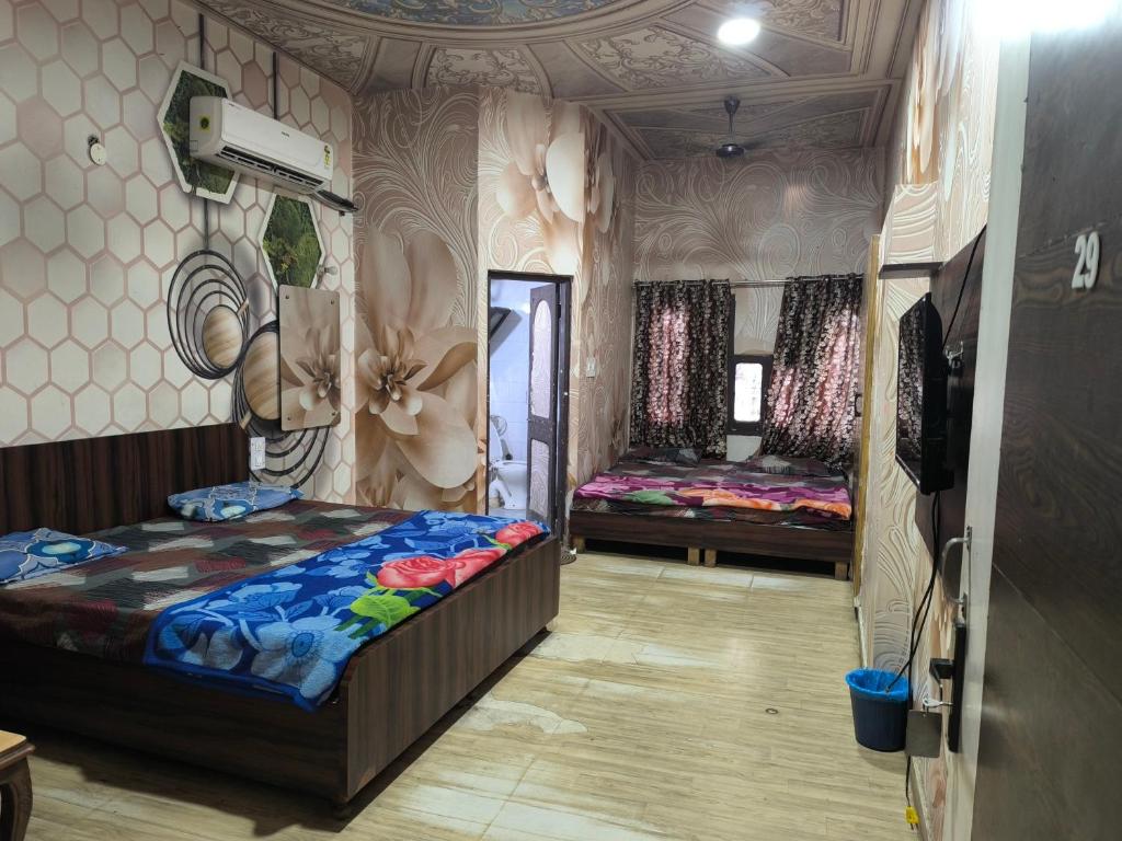 a bedroom with two beds in a room with a ceiling at HOTEL JOGI GUEST HOUSE 15min walk Golden temple10 min walk Railway Station and Bus stand in Amritsar