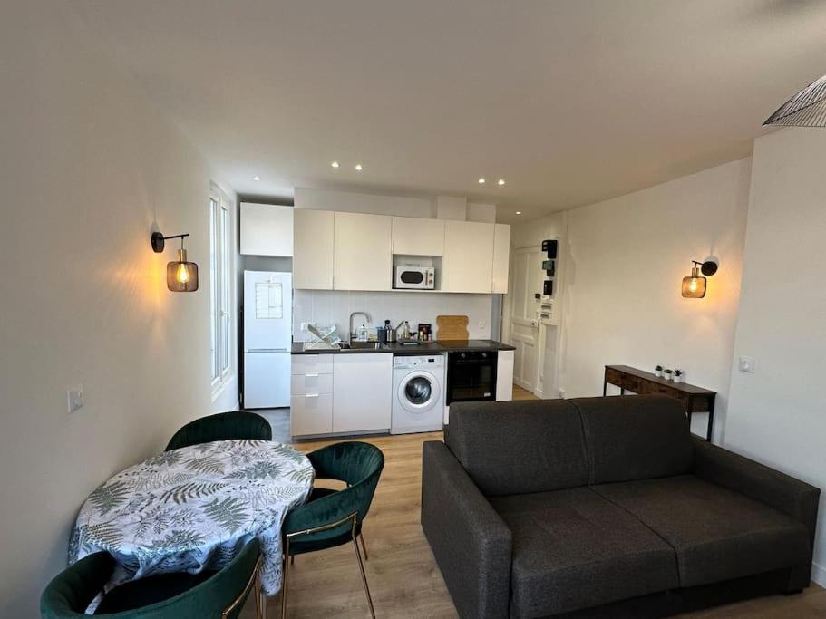 ein Wohnzimmer mit Sofa und Tisch in der Unterkunft Appartement Moderne in Gennevilliers