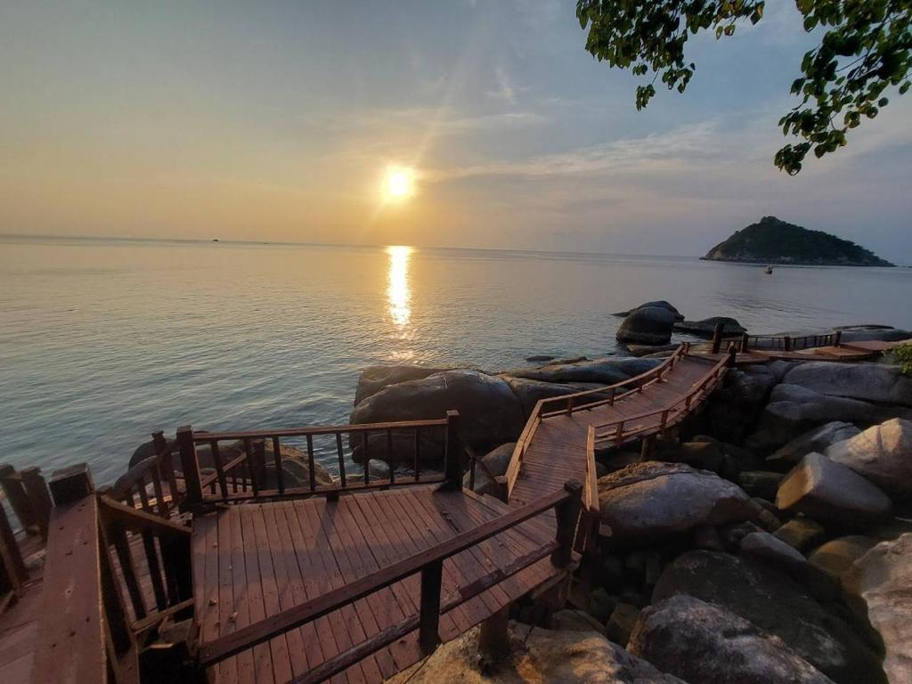 a sunset over a body of water with a dock at Dusit Buncha Koh Tao by Riya Group in Ko Tao