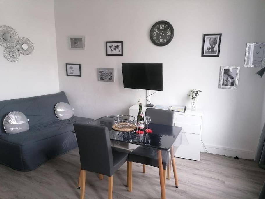 un salon avec une table et un canapé dans l'établissement Comme une évidence, à Fécamp