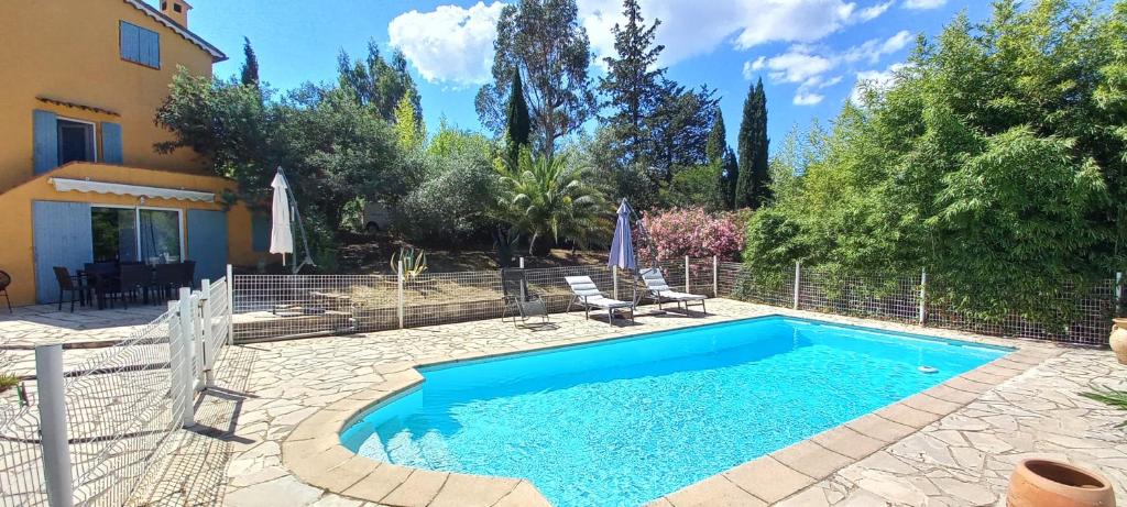 une piscine dans une cour à côté d'une maison dans l'établissement Bastide La Sauvagère, à Auribeau-sur-Siagne