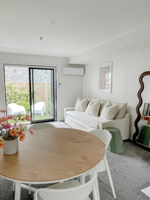 a living room with a table and a couch at Hagley Park Townhouse in Christchurch