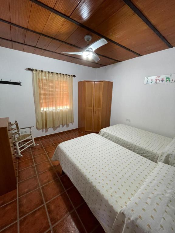 a bedroom with two beds and a ceiling fan at Villa Toliso in Alora