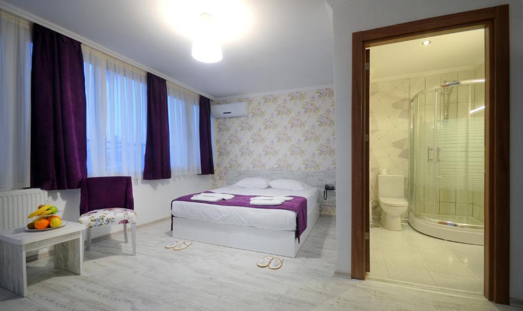 1 dormitorio con 1 cama y baño con ducha en Hotel Abro Sezenler, en Ankara