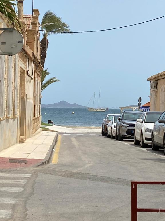 una calle con coches estacionados junto al océano en Paradise Costa en Los alcázares, en Los Alcázares
