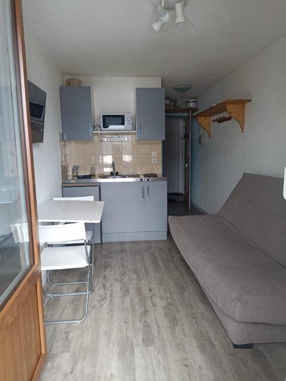 Cette petite chambre dispose d'une cuisine et d'un canapé. dans l'établissement Appartement au calme, aux Rousses