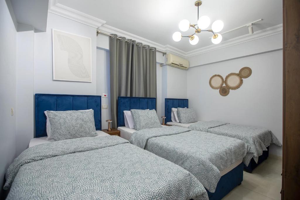 a group of four beds in a room at Skyline Premium Properties in Alexandria