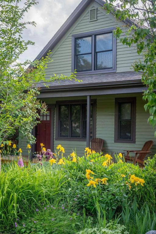 a green house with flowers in front of it at Garden House in Livingston