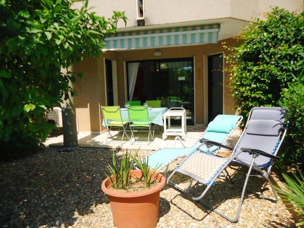 - un ensemble de chaises et de chaises de jardin sur une terrasse dans l'établissement Bel Appartement 2 Pièces Climatisé proche Plages, à Cavalaire-sur-Mer