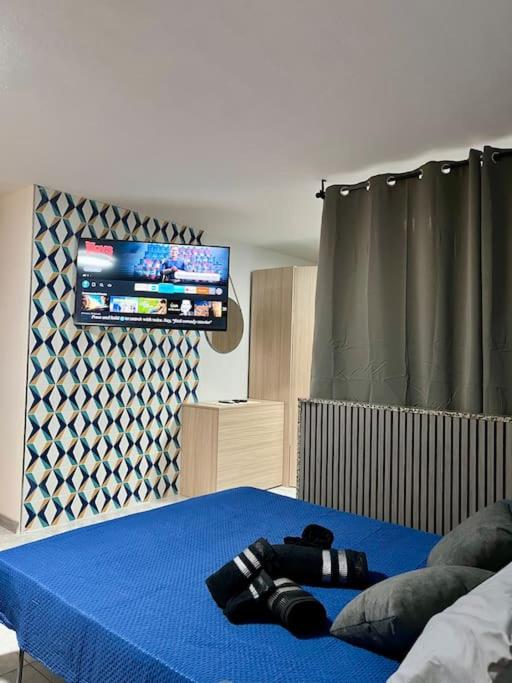 una camera con un letto con una coperta blu e una TV di Iris Chic Residence a Marsaskala