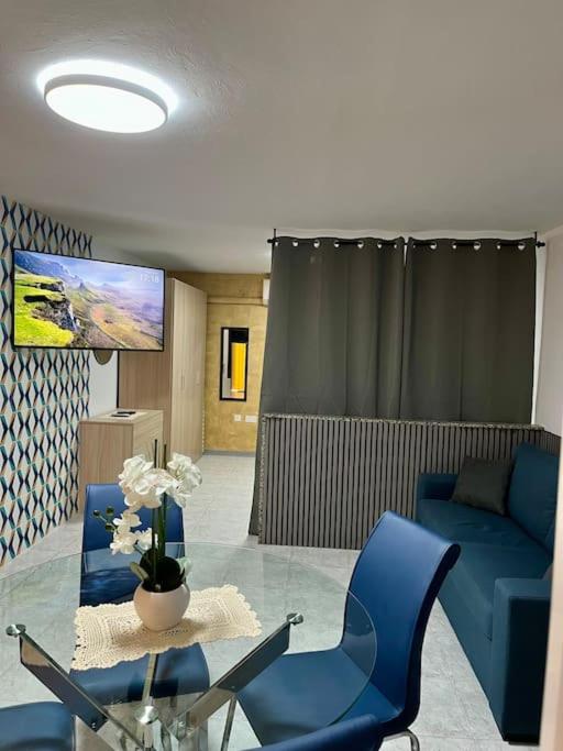un soggiorno con divano blu e tavolo in vetro di Iris Chic Residence a Marsaskala