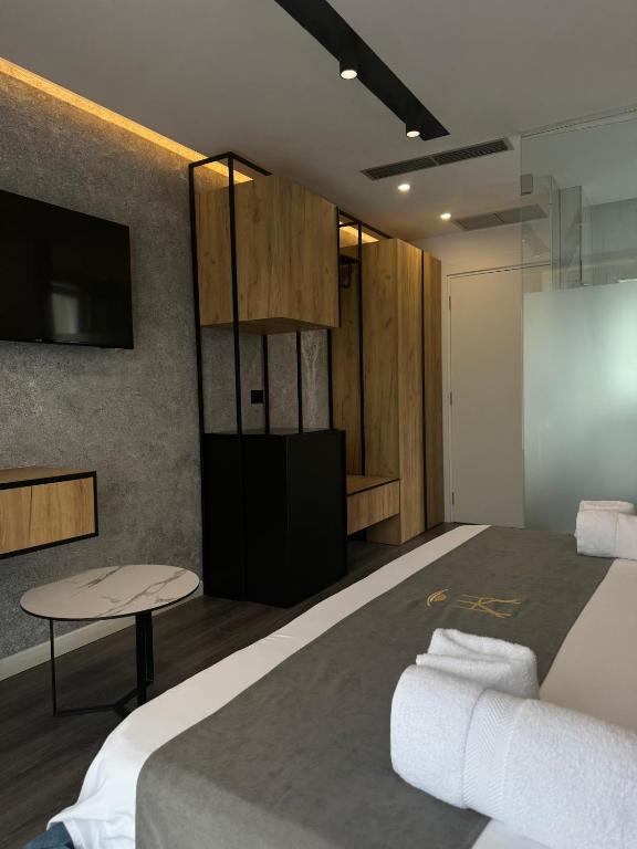 a room with a bed and a tv and a table at HOTEL BAR RESTORANT YLLI in Shëngjin