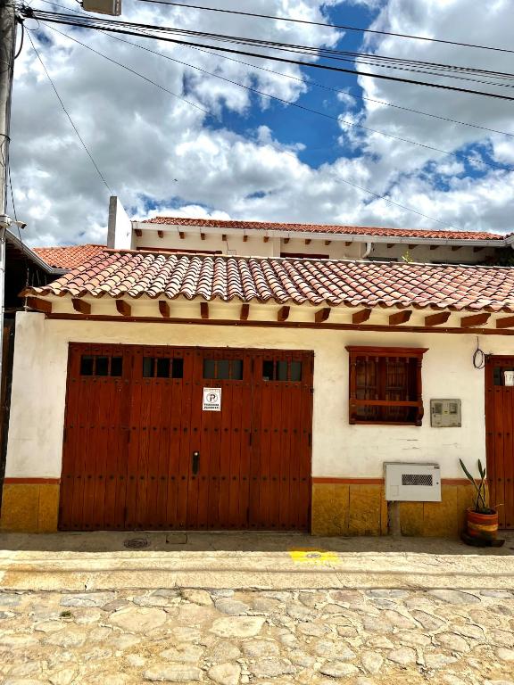 a white house with a red garage door at Casa familiar RS in Villa de Leyva