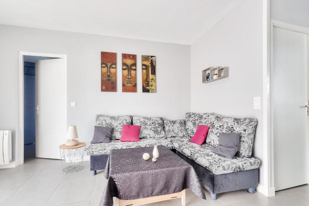 un salon blanc avec un canapé et des coussins roses dans l'établissement Résidence Villers 2000 - Maeva Home - Appartement 3 pièces 4 personnes - Sélection MAE-5631, à Villers-sur-Mer