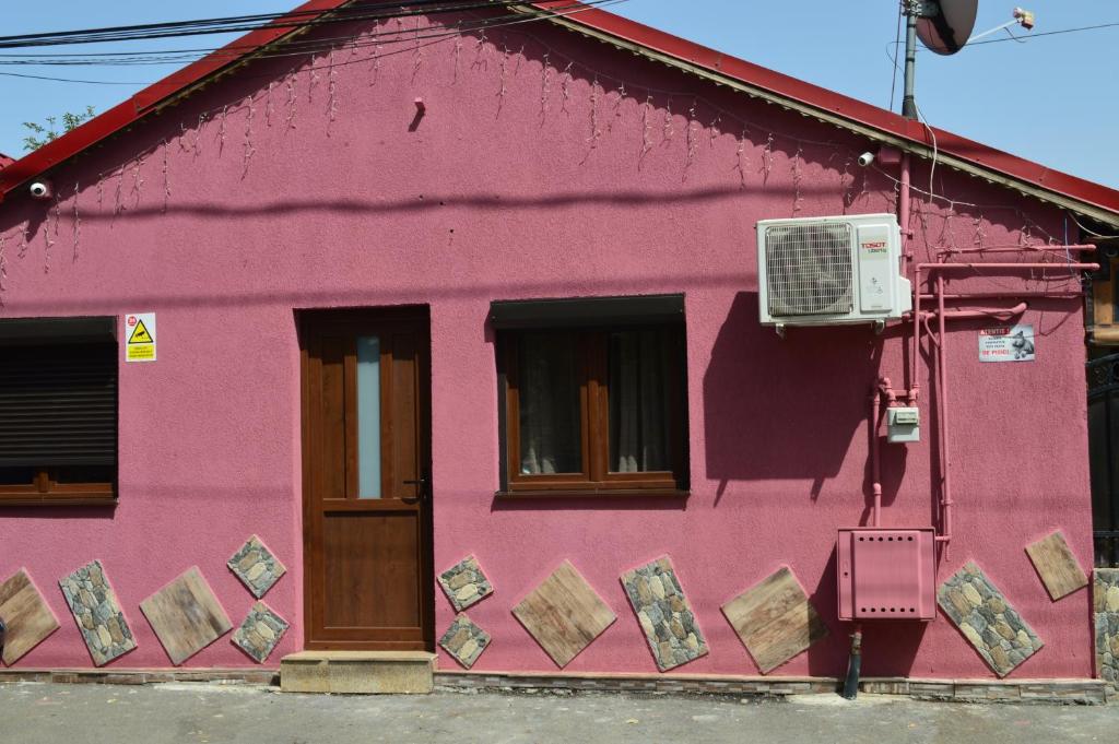 een roze gebouw met een raam en een airconditioning bij YNA House in Boekarest