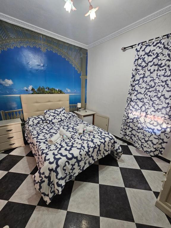 a bedroom with a bed and a checkered floor at Hostal Sevillana Costa in Chipiona