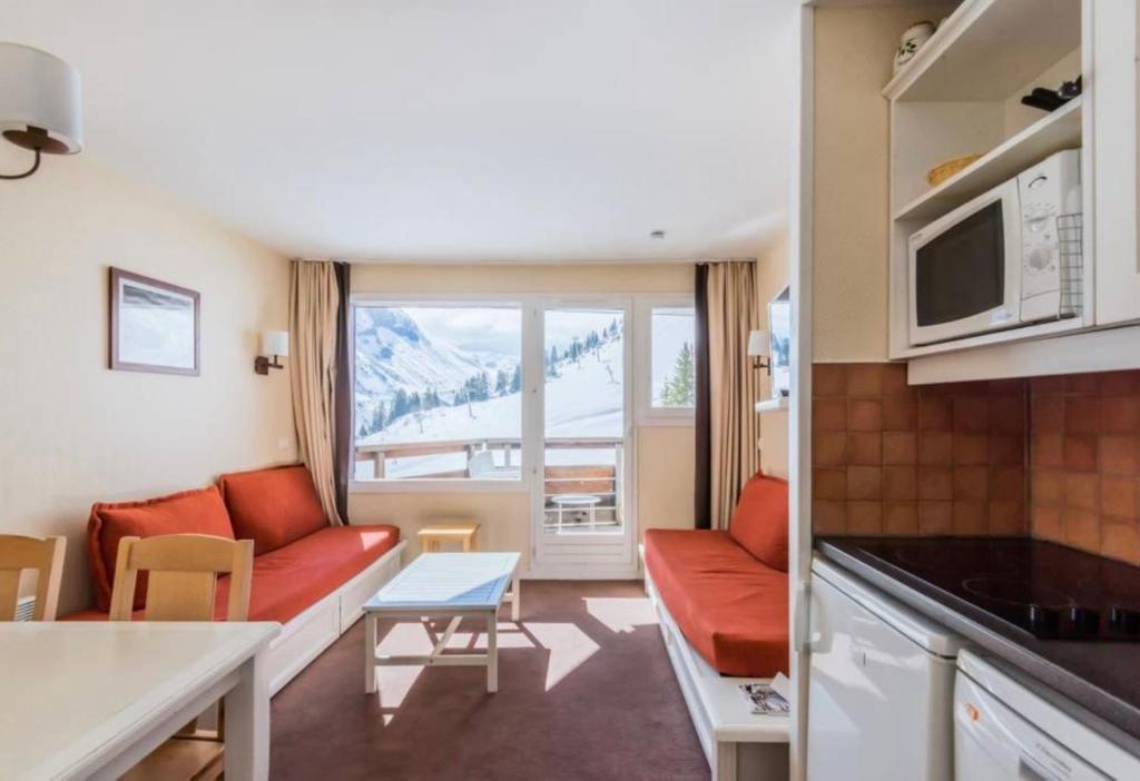Avoriaz - Portes du Soleil : Aux pieds des pistes في مورزين: غرفة معيشة صغيرة مع أريكة ومطبخ