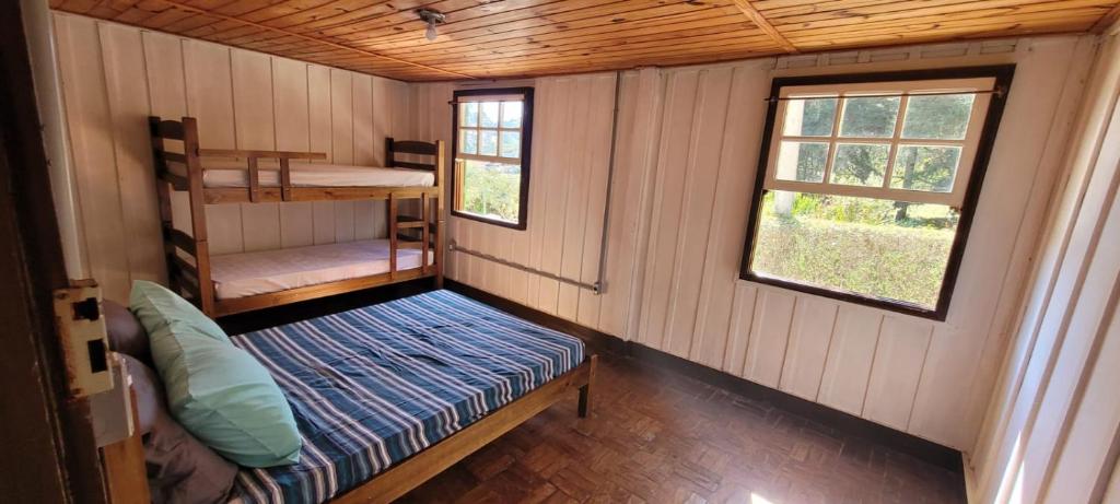 Habitación pequeña con 1 cama y 1 litera en Casa Violeta, en Campos do Jordão