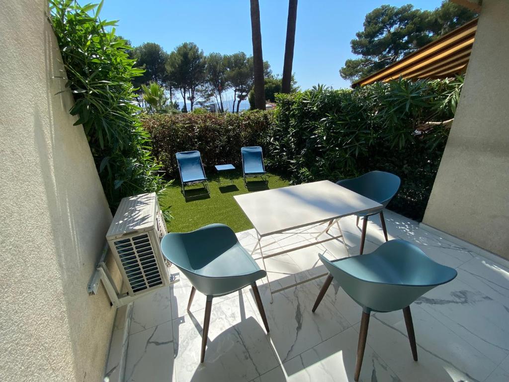 une terrasse avec quatre chaises, une table et des chaises dans l'établissement Appartement face mer et port Santa Lucia climatisé et wifi, à Saint-Raphaël