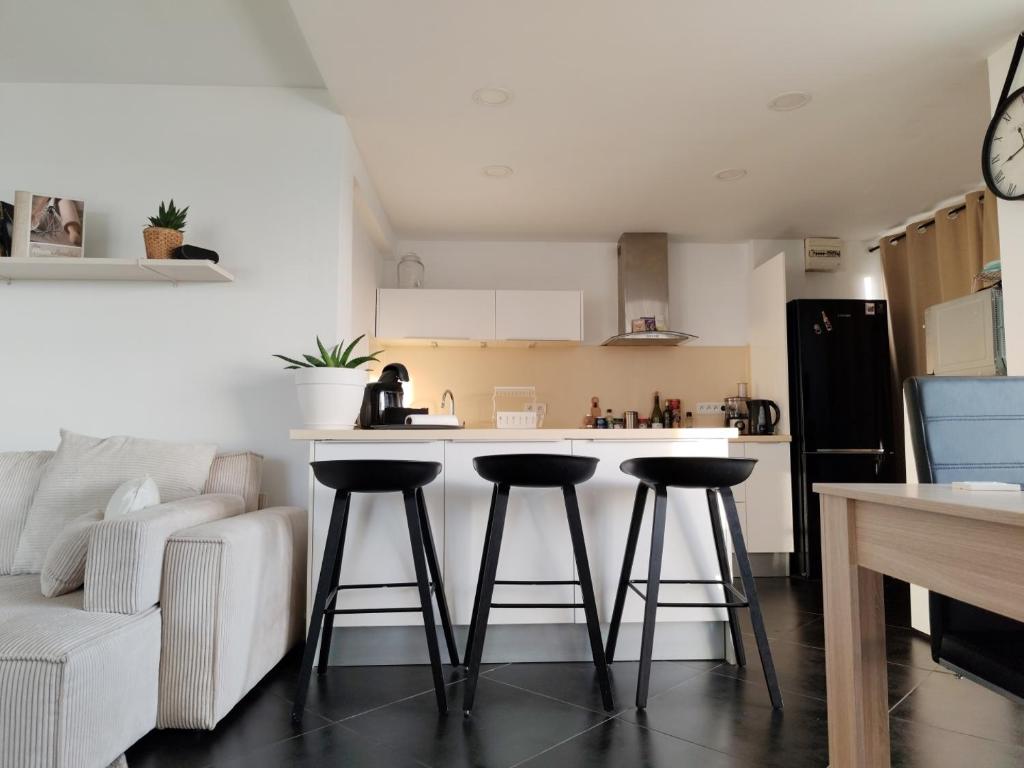 une cuisine avec un comptoir et deux tabourets de bar dans l'établissement Appart vu panoramique Marseille, à Marseille