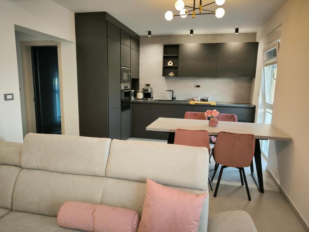 ein Wohnzimmer und eine Küche mit Sofa und Tisch in der Unterkunft Luxury Apartments Marina View in Vodice