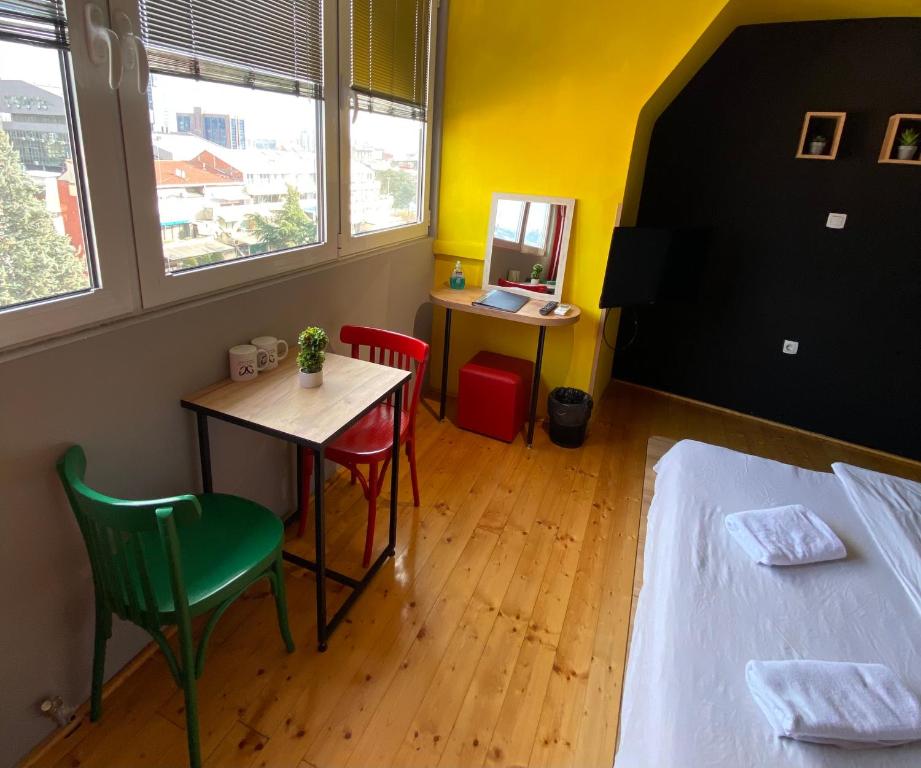 una habitación con una cama, una mesa y sillas en Mickitos Long Term Rooms, en Skopje