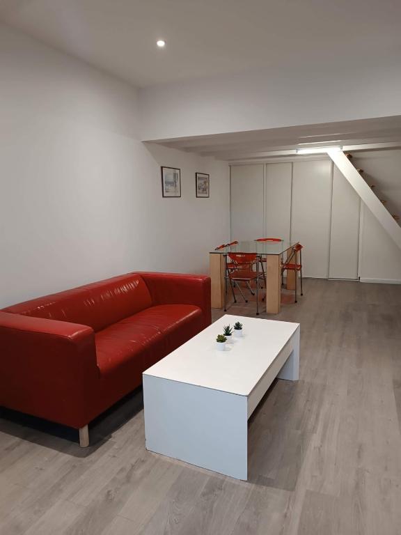- un salon avec un canapé rouge et une table blanche dans l'établissement Maison de ville vitry, à Vitry-sur-Seine