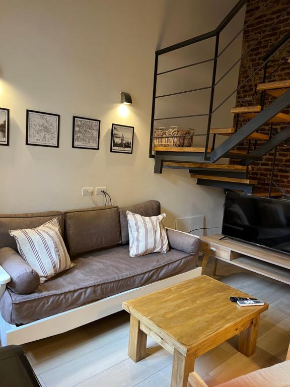een woonkamer met een bank en een tafel bij Loft 3 11 de Abril in Bahía Blanca