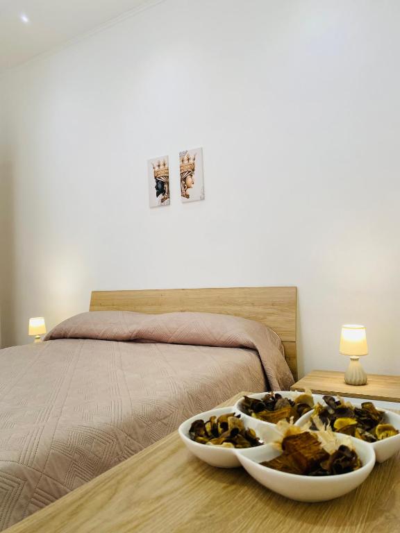 a bed with two bowls of food on a table at Il Cortiletto Casa Vacanze in Pachino