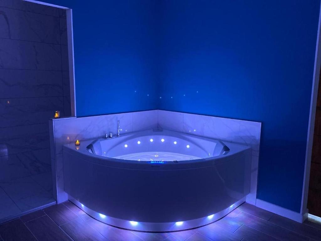 ein blaues Bad mit einer Badewanne mit Beleuchtung in der Unterkunft Bulles de bonheur - Carcassonne in Carcassonne