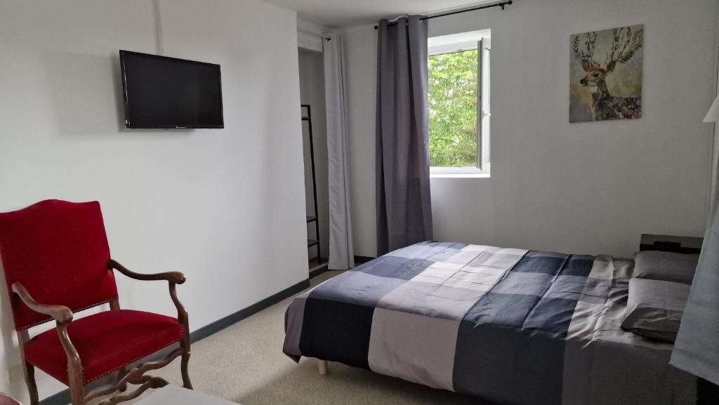une chambre avec un lit et une chaise rouge dans l'établissement Domaine de Bernede, à Pomarez