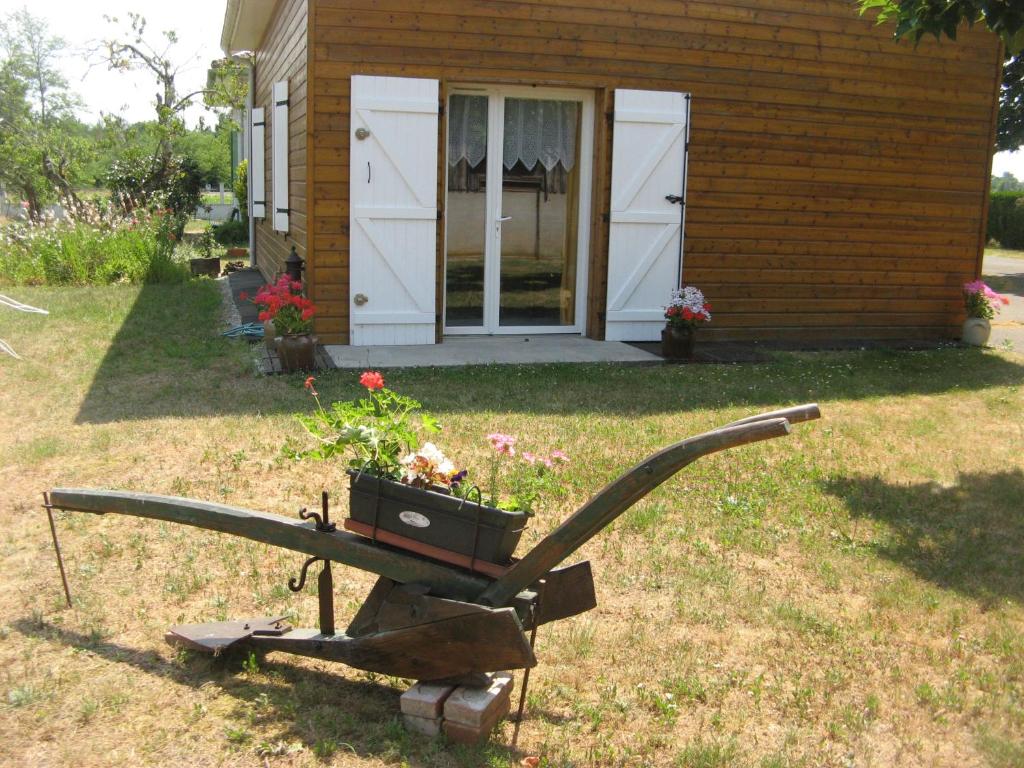 a garden cart with a planter in front of a house at La Petite Mongesse in Morcenx