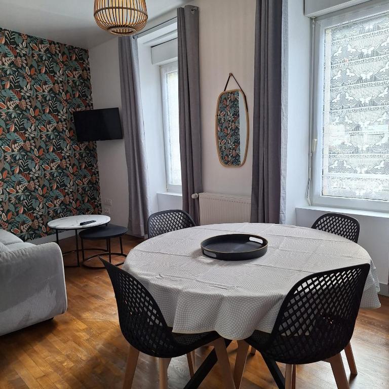 un soggiorno con tavolo e sedie di Appartement RDC centre ville - Local vélos disponible a Mayenne