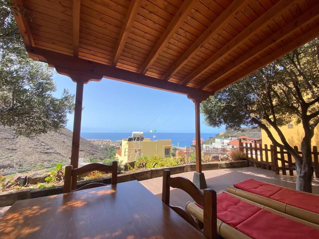 a porch with a table and a view of the ocean at Casa Roja La Calera in Valle Gran Rey
