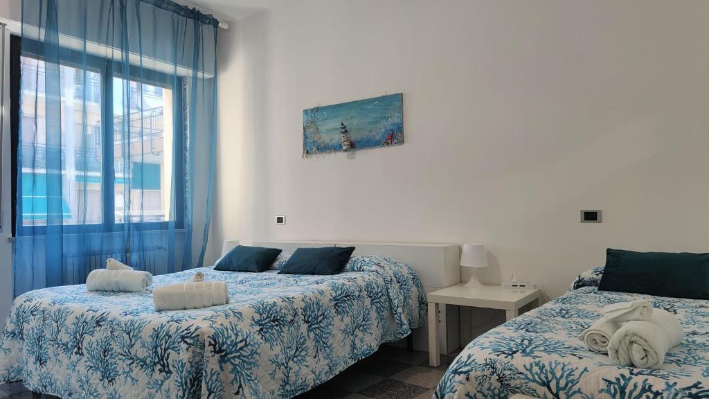 a bedroom with two beds and a window at Casa Mario in Loano
