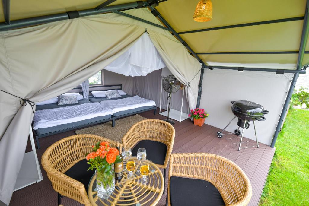 a tent with a bed and chairs and a table at KempingZator Glamping in Zator
