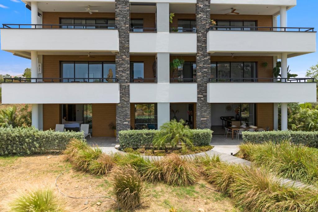 an exterior view of a building with palm trees at The Shore 2 luxury beach front condo in Willemstad