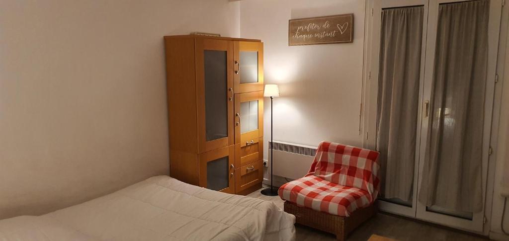 - une chambre avec un lit, une armoire et une chaise dans l'établissement La Fayette, à Cannes