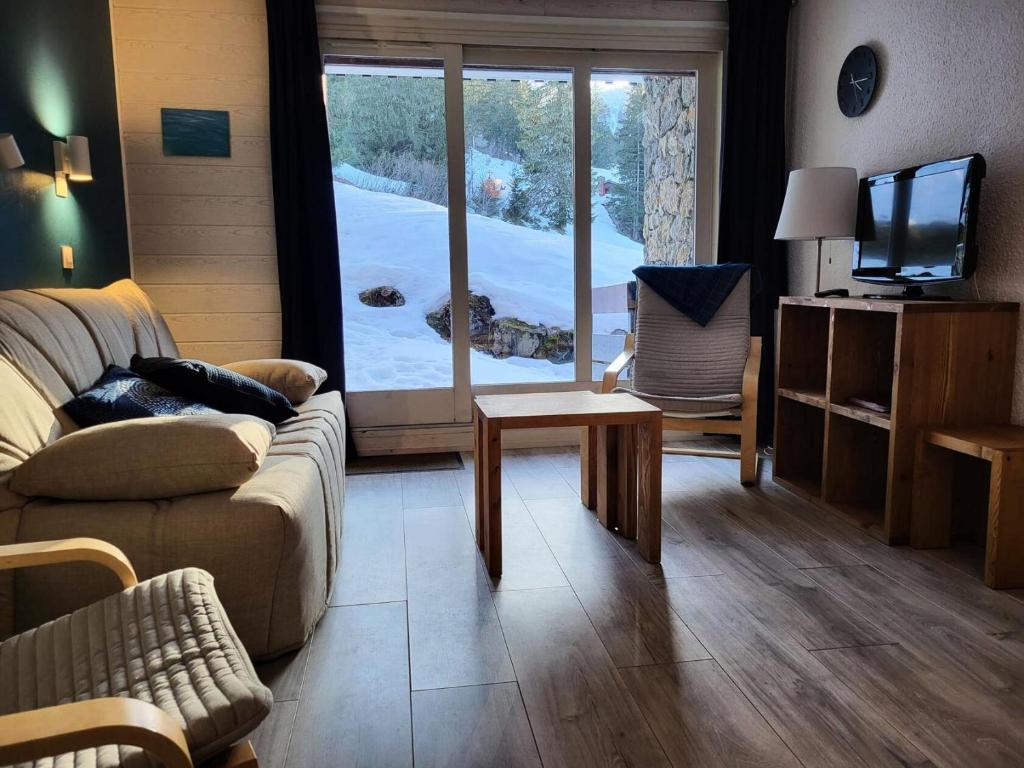 un salon avec un canapé et une télévision dans l'établissement Résidence Cheval Noir - Le Cheval Noir 9 - 2 pièces joliment rénové avec terrasse MAE-5584, à Valmorel