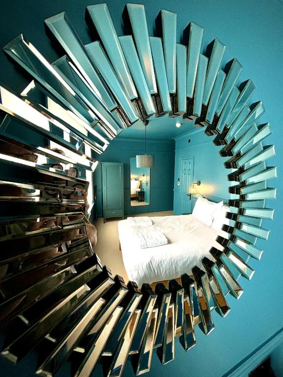 プールにあるROOMS AT THE QUAYSIDE - stylish en-suite rooms on Poole Quay all fully refurbedのベッドルーム(ベッド1台、大きな円形鏡付)