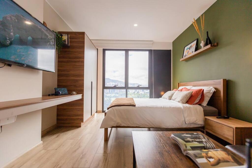 Un dormitorio con una cama y una ventana grande. en XOE Designer Studio, en Quito