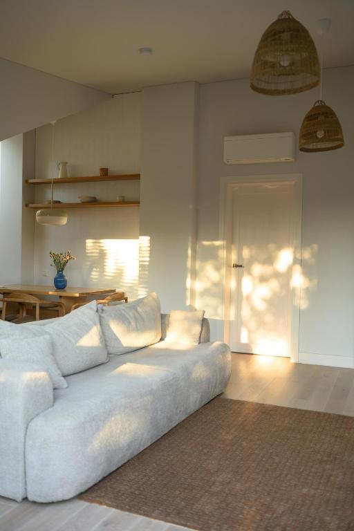 a living room with a white couch and a table at Pine Attic - new & cozy 3 bedroom apartment,Nida in Nida