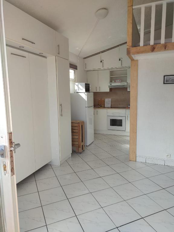 Il comprend une cuisine avec des placards blancs et du carrelage blanc. dans l'établissement Studio mezzanine, au Barcarès
