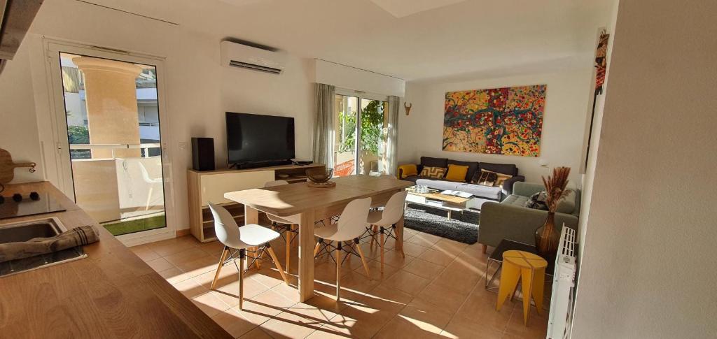 une cuisine et un salon avec une table et des chaises dans l'établissement Palais Nausicaa, à Cannes