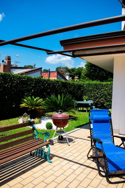 a patio with a bench and a chair and toy figures at Maison Martina in Ariccia