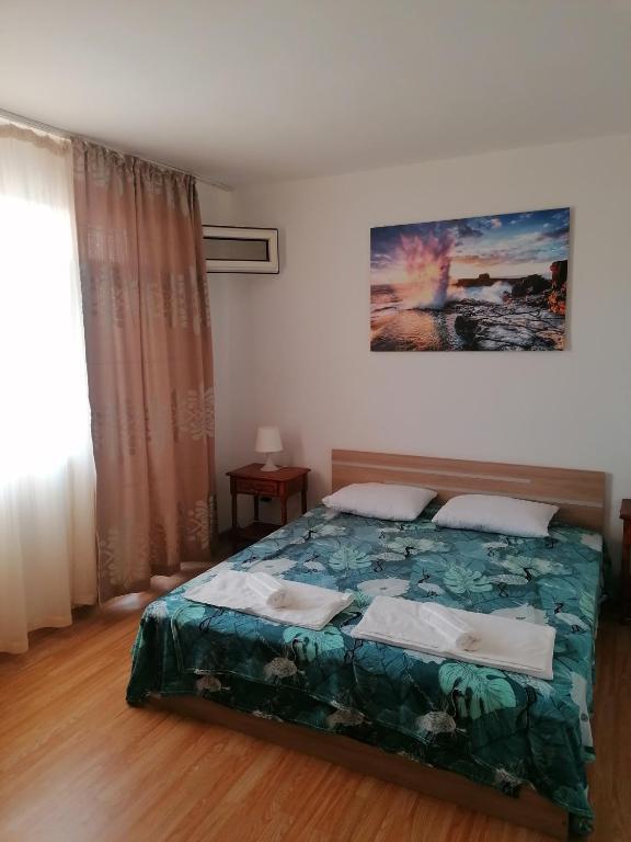 Un dormitorio con una cama con un edredón verde. en Апартаменти Захариеви 4, en Byala