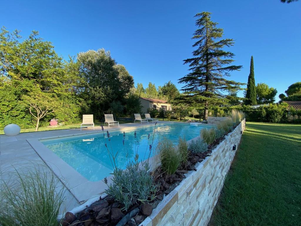 - une piscine dans une cour avec un mur de retenue dans l'établissement Le gîte des oliviers, à Sarrians